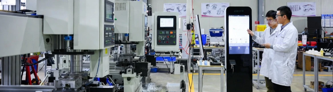 LEGOYO interactive kiosk manufacturing facility in Xiamen featuring CNC machines and R&D engineers demonstrating in-house production capabilities.